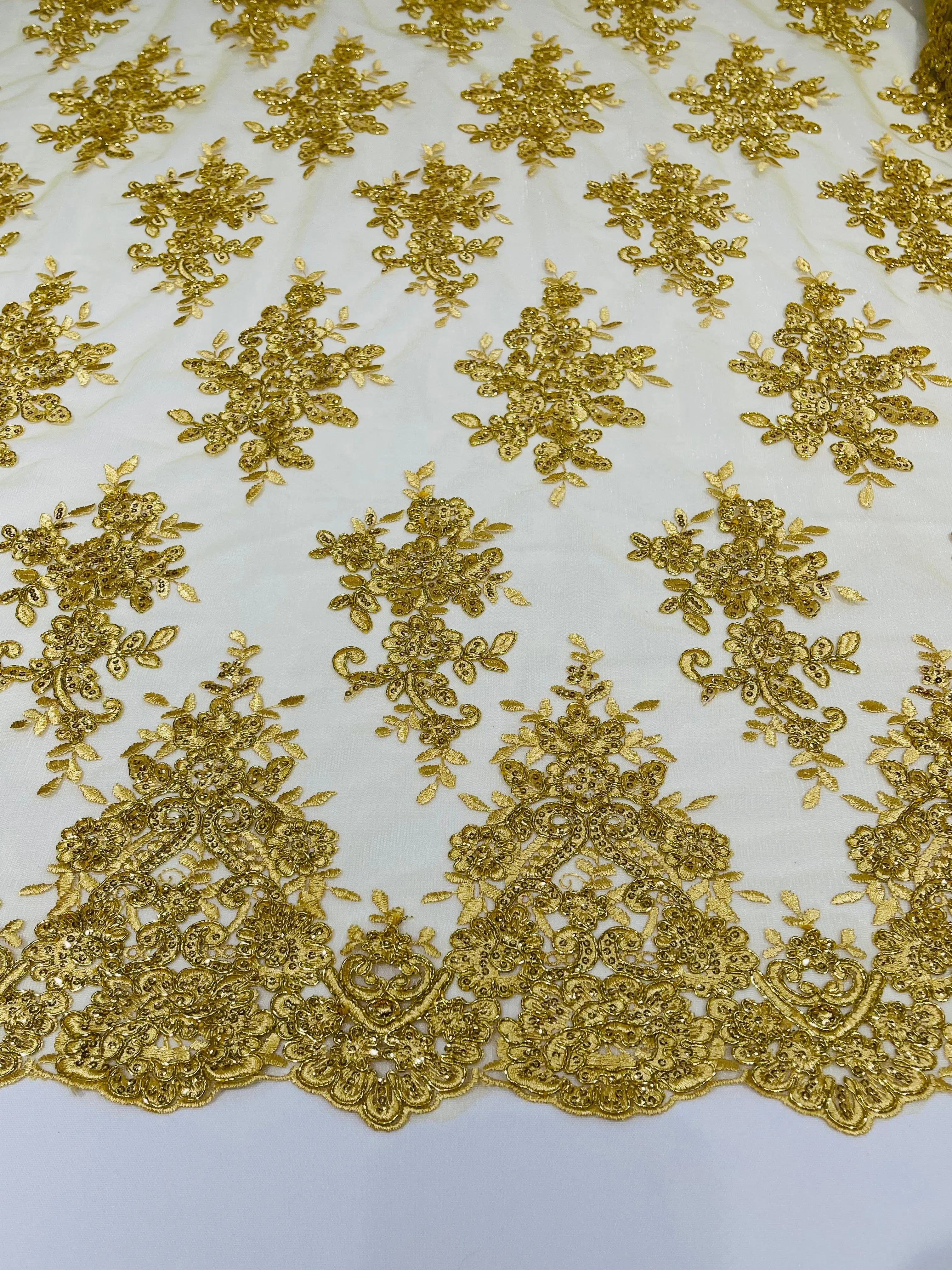 Gold Metallic floral design embroidery on a mesh lace with sequins and cord-sold by the yard.